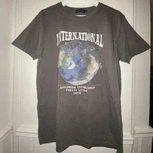 Charcoal oversized tee prettylittlething - Oversized grå t skirt från prettylittlething med snyggt motiv på framsidan Storlek M