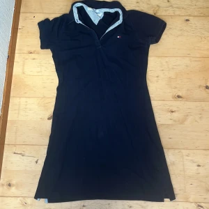 Tommy Hilfiger pikéklänning - Jättefin marinblå Tommy Hilfiger klänning i bra skick. Den tredje knappen vid kragen saknas dock, vilket visas på bild 2. Kroppsnära. Storlek S. Köparen står för frakt