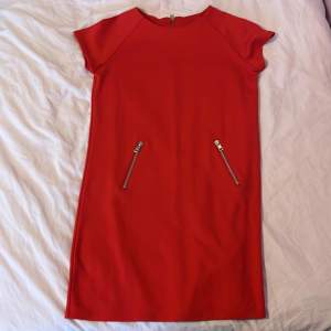 En röd klänning med dragkedjor perfekt till julen i strl 170. Kan dock passa strl S. 