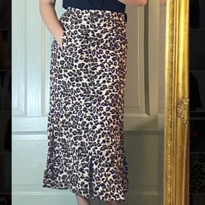 Leopard kjol från Urbanoutfitters - Från urbanputfitters, använd en gång. Strlk S, knappar fram som går nästan hela vägen ner men lämnar en liten slits fram som man kan justera med hur många knappar man väljer att knäppa. Väldigt luftig och skön 