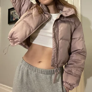 Cropped winter jacket - Varm och gosig croppad jacka, färgen är baby/urtvättad rosa. Glitter detalj på armen som är väldigt 00’s. Endast använd 2 gånger så superbra skick!