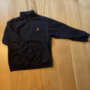 Carharrt Tröja - Carharrt WIP tröja med dragkedja vid halsen. Mycket bra skick, inga fläckar eller skador, så gott som ny.  Tjockt tyg och kraftiga sömmar. Storlek M. 