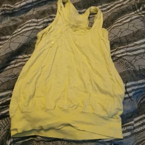 Gult linne - Ett gult linne med knappar och rsår i midjan ganska kort men inte som en magtröja 💕💕