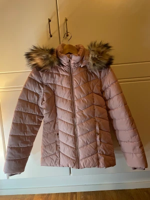 Vinterjacka  - Rosa snygg vinterjacka med fuskpäls krage. Använd och super skön. Hel och fin