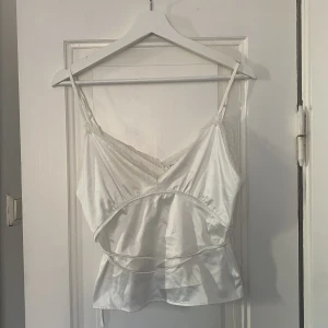 Zara spetslinne  - Ett vit spetslinne i satin från Zara. Använt endast 2 gånger och är i storlek S. 