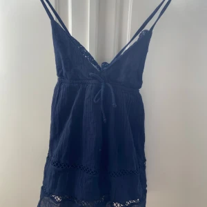 Mörkblå topp - Supersöt mörkblå topp från Gina Tricot med tunna axelband, v-ringning och knyt. Spetsdetaljerna upptill är tillsydda💕storlek 170, men som en xs💕