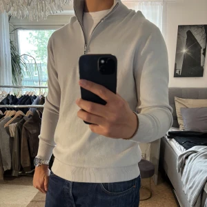 Ljusgrå half zip tröja från MNG - Snygg ljusgrå tröja från MNG med half zip och hög krage. Tröjan är stickad i mjuk bomull och har en clean look med ribbade muddar och lång ärm. Perfekt för lager-på-lager och chill stil.