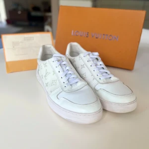 Snygga vita sneakers - Snygga vita sneakers med klassiskt monogrammönster i ljusgrått. Skorna har rund tå, vita snören och detaljer i skinn och canvas🔥 Perfekta för dig som vill ha en exklusiv och stilren look med lyxig känsla🤵🏼