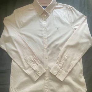 Ljusrosa skjorta från Gant - Nästan helt ny, men aldrig använd!  Klassisk Gant-skjorta i snygg ljusrosa färg. Storlek 158-164cm (passar 13–14 år). Inga fläckar, inga skador eller likande  Priset är inte hugg i sten, går att diskuteras