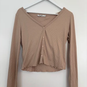 Kofta med fina detaljer  - Säljer en kofta från NAKD  med fina volangdetaljer vid ärmslutet. Endast använd 1 gång, så i princip nyskick! 