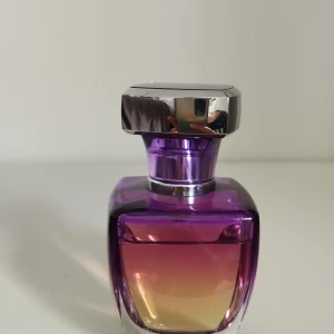 Paris Hilton Tease parfym 50ml - Snygg parfymflaska från Paris Hilton, modellen Tease. Doften är mjuk och feminin med noter av vita blommor. Top notes are Red Apple, Peach and Bergamot; middle notes are Tuberose, Jasmine and Frangipani; base notes are Sand, Woodsy Notes and Amber. Flaskan rymmer 50 ml.
