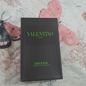 Valentino Uomo Born In Roma Green Stravaganza - Parfymen Valentino Uomo Born In Roma Green Stravaganza kommer i en cool, svart kartong med neongrön text. Flaskan är 100 ml, tillverkad i mönstrat glas med nitar och svart kork med Valentino-logga. Modern och edgy design som sticker ut i badrumshyllan.