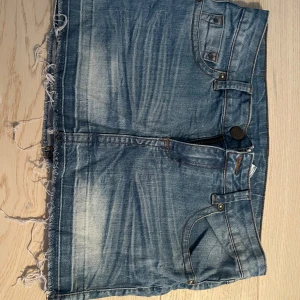 Blå jeanskjol med fransig kant - Snygg blå jeanskjol från mango! Passar xs-s