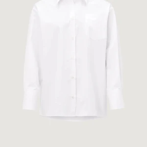 Vit skjorta från ÀVORA i bomull - Klassisk vit skjorta från ÀVORA i bomull med lång ärm, bröstficka och diskret broderad logga. Skjortan har oversized passform och stängs med knappar framtill. Perfekt för en clean och stilren look. Endast provad en gång. Nypris 1600kr