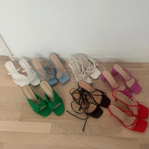 10 par klackskor för 300kr - Säljer flera par trendiga sandaler med fyrkantig tå och klack i olika färger: vitt, ljusblått, grönt, svart, rött, rosa och lila. Vissa har tunna remmar och snörning runt vristen, andra har breda korsade band. Dom är från Shein, att köpa separat hade kostat ca 1400, lite mer. Passar både 37 och 38