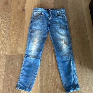 Blå Replay jeans, waist 30/32 - Snygga blå jeans från Replay med slitningar framtill och klassiska bakfickor med broderad detalj. Modellen anbass. Perfekta för dig som gillar en avslappnad men ändå stilren look.