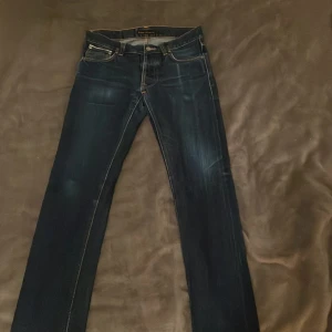 Mörkblå jeans från Nudie Jeans slim fit. - Snygga mörkblå jeans från Nudie Jeans med klassisk femficksdesign Jeansen har en slim fit passform, hör av er om ni har frågor!