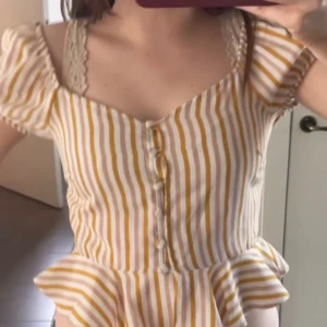 Randig blus med volang och knappar - Superfin blus med gula och vita ränder, v-ringad och med puffärmar.(S/XS) Pris går att diskutera🩷