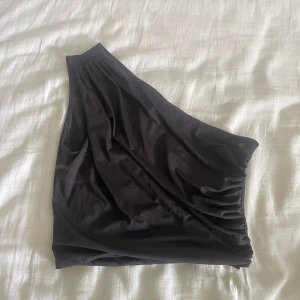 Svart oneshoulder topp - Snygg svart oneshoulder topp från h&m, perfekt att styla med jeans eller kjol. Nypris 100kr, pris går att diskutera 