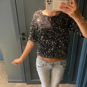 Svart glittrig croppad topp - Säljer en svart croppad topp med massor av glittrande paljetter. Storlek XS💞🌸kan förmodligen sänka pris vid förhandling🫶🏼