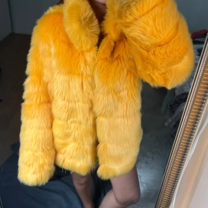 Gul pälsjacka  - Säljer en supermjuk och fluffig gul pälsjacka med bred krage och oversized passform. Jackan har långa ärmar och en riktigt statement look som drar blickarna till sig. Perfekt för dig som vill sticka ut och hålla dig varm under kalla dagar.