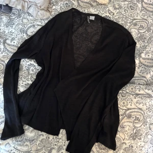 Svart kofta från Divided H&M - Svart, tunn och lätt kofta från Divided H&M med lång ärm och öppen front. Enkel design som funkar till många outfits.