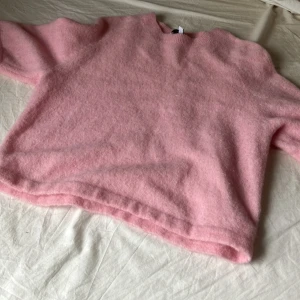 Rosa stickad tröja från & Other Stories - Supermjuk och fluffig rosa stickad tröja från & Other Stories. Tröjan har rund halsringning och kort ärm. Den har en loose passform och är i ett skönt material. Skick 10/10.