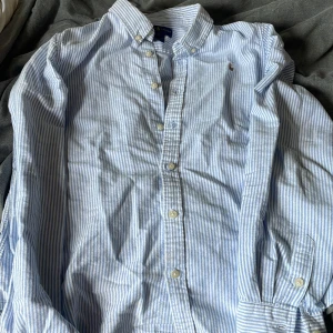 Ralph lauren skjorta - Klassisk skjorta från Ralph Lauren i vitt och ljusblått med smala ränder. Priset går att diskutera. Mycket bra pris 