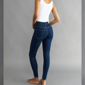 Molly Mörkblå skinny jeans med hög midja - Snygga mörkblå skinny jeans med hög midja och klassiska fickor både fram och bak. Jeansen har smal passform och är sydda i stretchigt denimtyg. Finns inte längre på hemsidan. Använda ett fåtal gånger. 