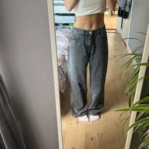 Gråa wide jeans med vintagekänsla från Dazy  - Säljer ett par gråa jeans med tvättad look och loose fit. Byxorna har hög midja, raka vida ben och klassiska femficksdetaljer. Perfekta för dig som gillar avslappnad och trendig stil. Materialet är jeans och färgen är mörkgrå.