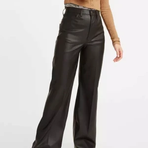 Levi's svarta high flare skinnbyxor  - Säljer ett par svarta 70’s flare byxor från Levi's i skinnimitation. Byxorna har hög midja, vida ben som är tightare över låren, och klassiska femficksdetaljer. Snyggt glansigt material och bälteshällor. Perfekta för dig som vill sticka ut med en edgy look. Helt oanvända eftersom de är stora i midjan på mig. Hade svårt att fånga dessa med min kamera, därav extra bilder. Nypris 1100kr. 