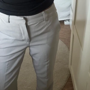 Beiga kostymbyxor med raka ben - Snygga beige/grå kostymbyxor från Bikbok storlek 34. Köpta för 499 säljer för 100, då de inte kommit till användning. Skulle säga att de är som nya 😊