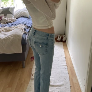 Ljusblå jeans från Gina Tricot - Säljer ett par ljusblå jeans från Gina Tricot i storlek 158. Jeansen har låg midja, bootcut och klassiska fickor med knappdetalj bak. Har ett litet hål i bak precis vid fickan men inget som syns tydligt, lätt att sy igen. Ganska korta i och tänk dig en storlek mindre än vad dem är. 