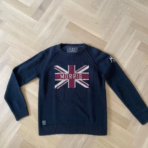 Mörkblå stickad tröja Morris - Snygg mörkblå stickad tröja från Morris med broderad logga på bröstet. Tröjan är i mycket bra skick då den knappt kommit till användning. Hör gärna av er för fler bilder eller funderingar😇✌️