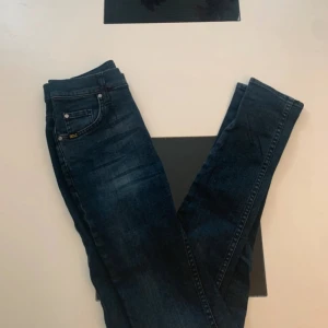 Mörkblå jeans Tiger of Sweden Kelly - Snygga mörkblå jeans från Tiger of Sweden i modellen Kelly. Klassisk femficksdesign med diskreta slitningar och silverfärgade nitar. Jeansen är raka och har en normal passform, perfekta till sneakers eller boots. Kom gärna med prisförslag ✌️