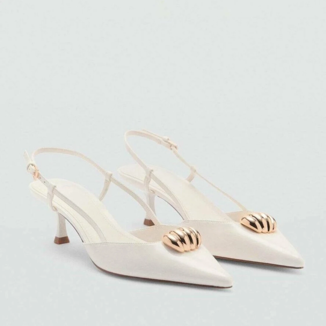 Vita klackar med gulddetalj från Mango