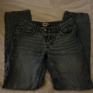 Blå raka jeans från 157, ICON - Klassiska blå jeans från 157 med raka ben och femficksmodell. Jeansen har en ljus tvätt och subtila slitningar på baksidan. Perfekta för en avslappnad och tidlös stil. Tillverkade i robust denim med normal passform och traditionell knappgylf.