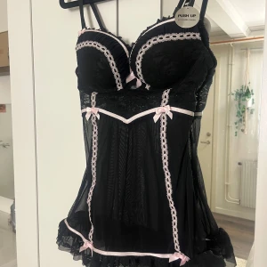 Svart push up med spets och rosetter - Säljer en supergullig helt ovanvänt pjamas linne med push up och lappen sitter fortfarande kvar💗den är i storlek 75B🫶