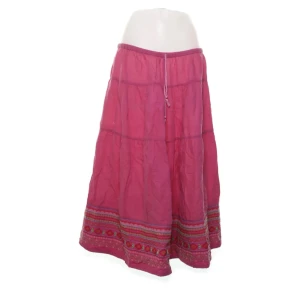 Rosa långkjol (Gudrun Sjöden)  - Snygg rosa långkjol med broderade detaljer och mönster längst ner. Kjolen har en avslappnad passform och dragsko i midjan för extra komfort. Perfekt för dig som gillar boho-stil och färgglada plagg.