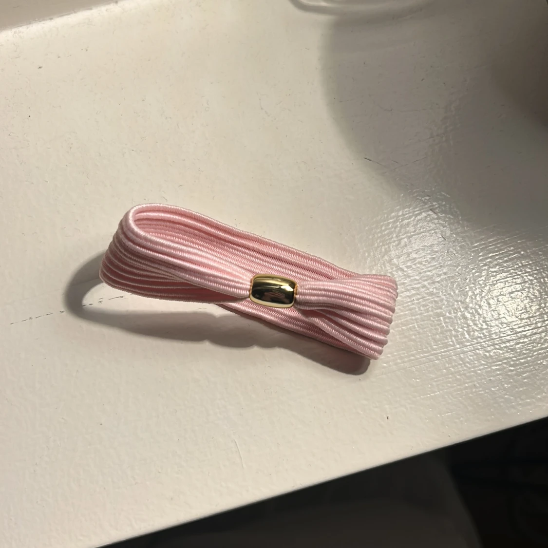 Rosa hårklämma med gulddetalj