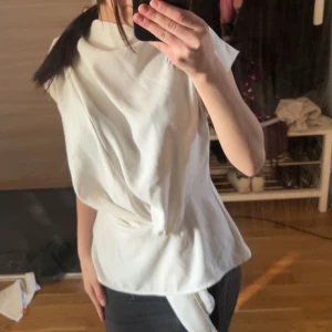 Vit blus från Zara - Säljer en stilren vit topp från Zara med korta ärmar och en knytning i midjan. Aldrig använd❤️