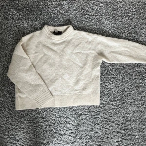 Beige stickad tröja från Bik Bok - Säljer en mysig beige stickad tröja från Bik Bok i alpackablandning. Tröjan har en rund hals och långa ärmar med ribbade muddar. Perfekt för kyliga dagar! Den är i storlek L men sitter bra på mig som brukar ha S. 