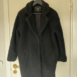 Svart teddyjacka / teddykappa - Svart kappa i Teddy-material från ONLY i storlek XS. 