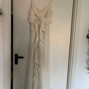 Vit långklänning från Bella Barnett - vit långklänning från Bella Barnett, endast testad. Originalpris 1000kr, pris kan diskuteras. Finns liten fläck på ryggen. 