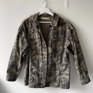 Jeansjacka från Zara - Camouflage jeansjacka från Zara med långa armar. Den har slitningar och fina gulddetaljer. I storlek XS men passar alltså från XS-M beroende på hur man vill att den ska sitta, kommer tyvärr inte till användning längre. Ge gärna prisförslag 💕✨