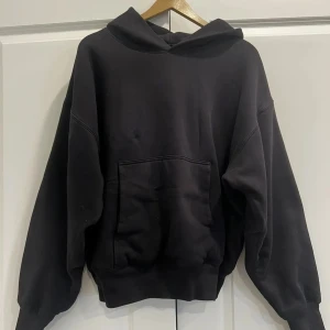 Svart Yeezy Gap hoodie - Säljer en Yeezy gap hoodie. Hoodien har en väldigt boxy fit och har krympt lite efter några tvättar och därför skulle jag säga att den är mer storlek S. Men den är perfekt för kyliga dagar då den är dubbellagrad med kvalité. Skicket är 9/10 eftersom att den har använts ett fåtalgånger men ändå är som ny om man tänker bort krympningen. Skriv om frågor eller funderingar!