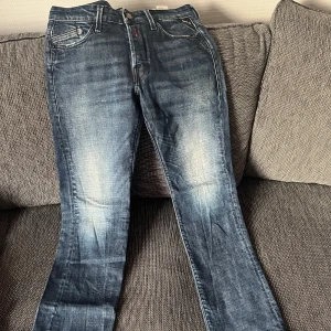 Replay jeans - Snygga blå jeans från Replay i modellen Waitom. Slim fit. Röd detalj vid gylfen. Mycket bra skick.
