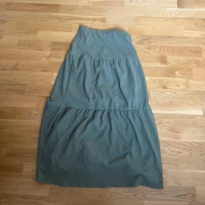 Grön långkjol från Kappahl - Säljer en grön långkjol från Kappahl. Kjolen har en enkel design med flera lager som ger en fin volym. Perfekt för en avslappnad stil. Storlek 146/152 men  Sitter som en xxs! Passar mig som är 156 