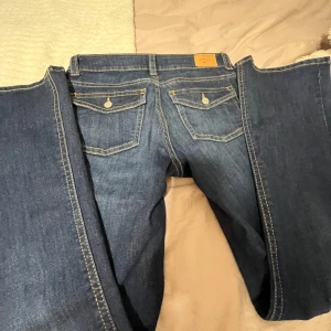 Mörkblå Jeans - Snygga blå jeans med klassisk design och kontrasterande sömmar. Byxorna har fickor på rumpan. Perfekta för en avslappnad stil. Säljs pga för stor storlek!