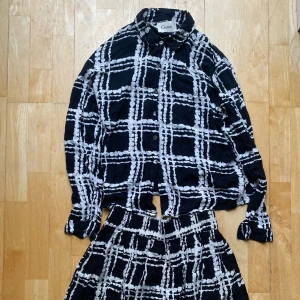 Ganni set blus+kjol XS - Set med rutig blus + minikjol från Ganni. Tunnt och mjukt material. Sparsamt använd, men en knapp har gått sönder på ens ärmen, men det påverkar ibte funktionen då den fortfarande går att knäppa (se sista bilden). Skickas från Berlin, frakt tillkommer:)